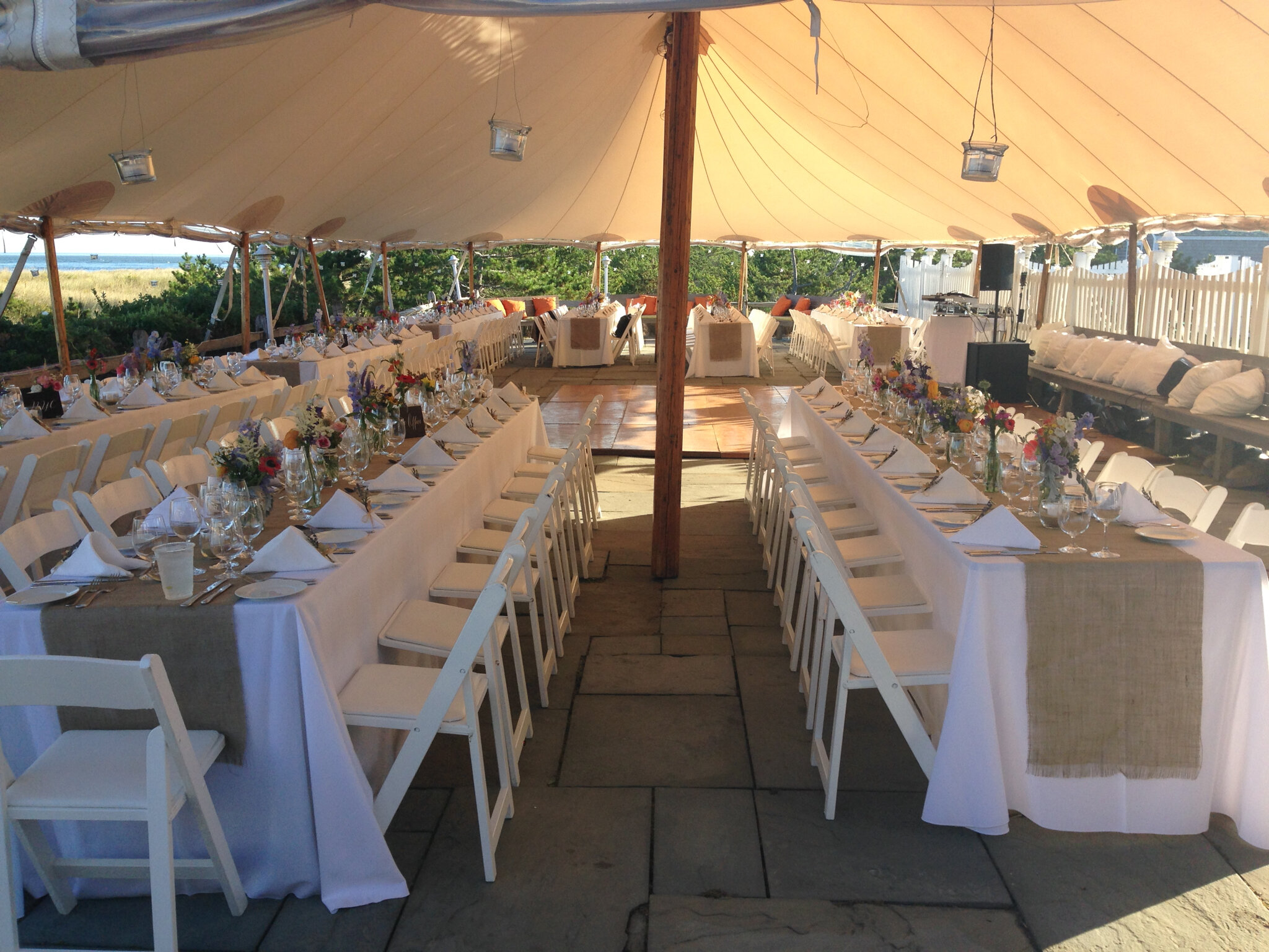 An outdoor event wedding party setup under a large tent structure