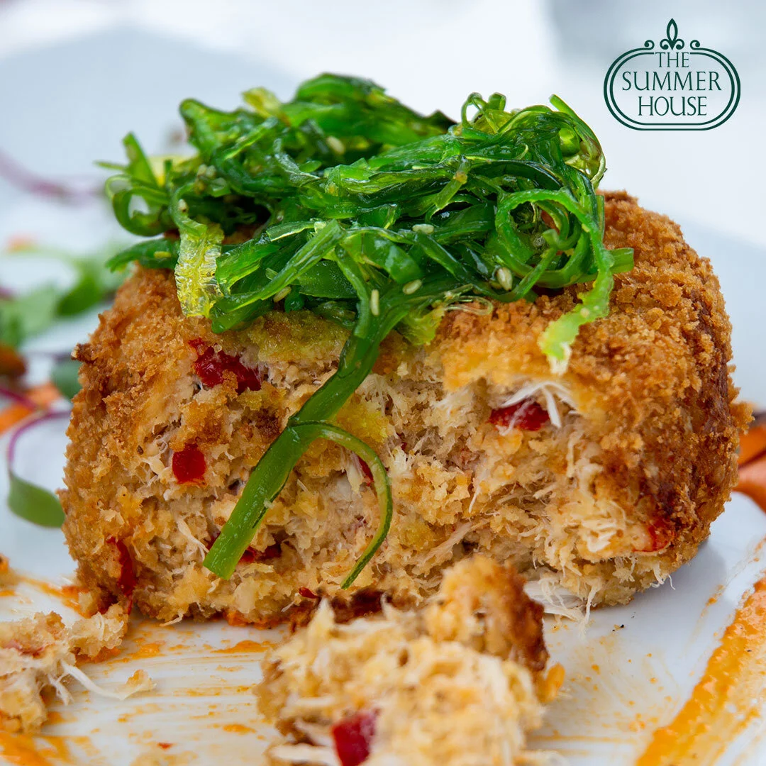 A crab cake topped with seaweed salad