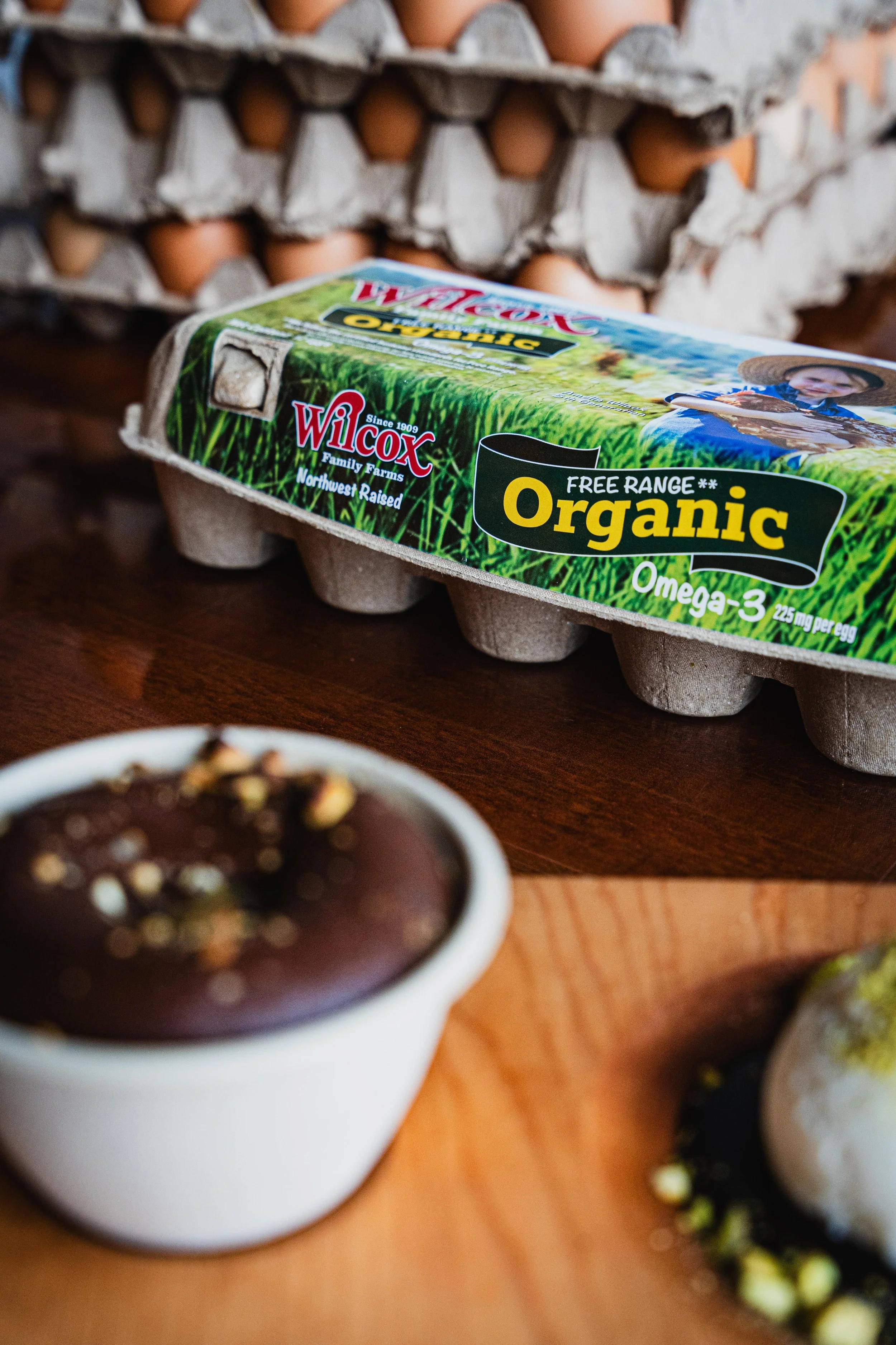 Wilcox Farms egg carton beside baking ingredients, representing farm-fresh eggs available throughout the Pacific Northwest.