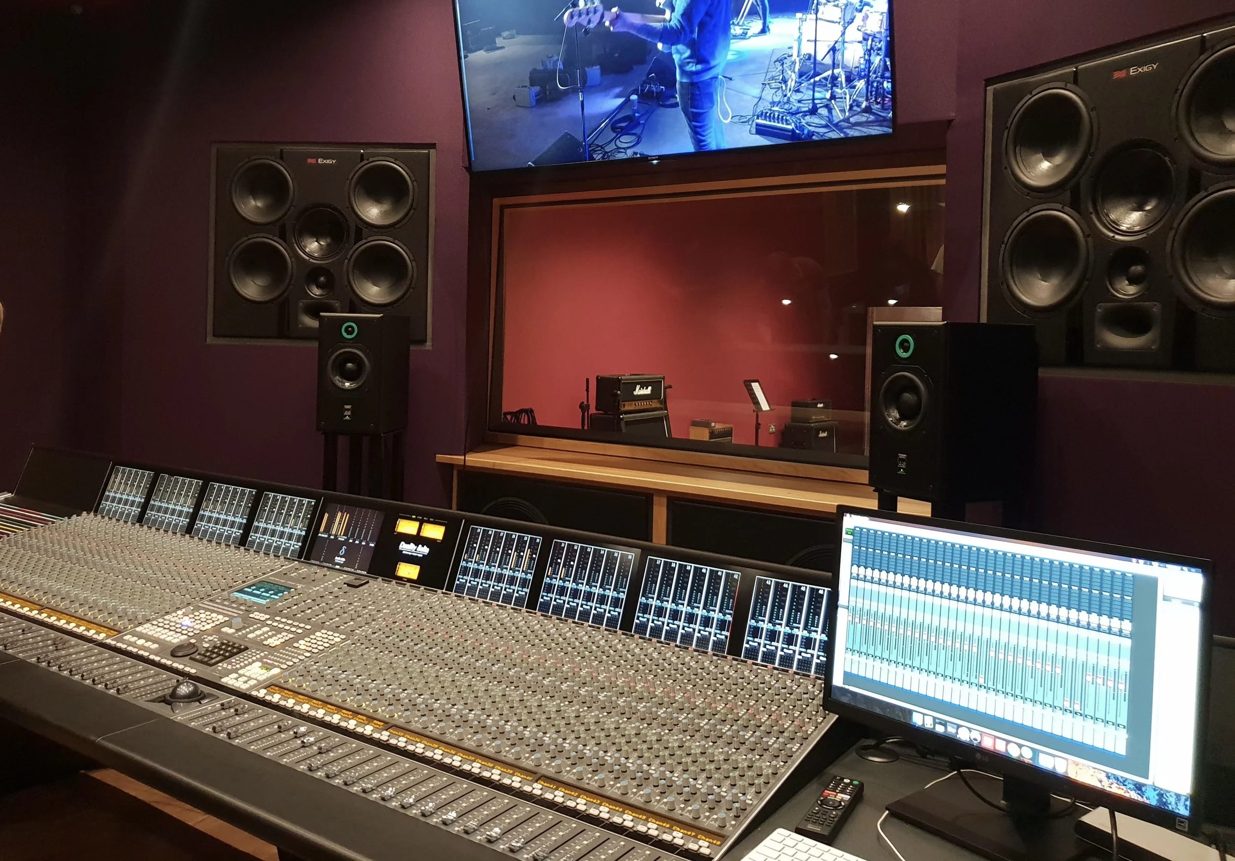 Metronome, Confetti, Recording studio with an SSL Duality Delta mixing console, studio monitors, a computer screen displaying Pro Tools, and a soundproof window showing musicians on the other side. Confetti ICT