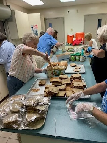 volunteers making and packing sandwiches