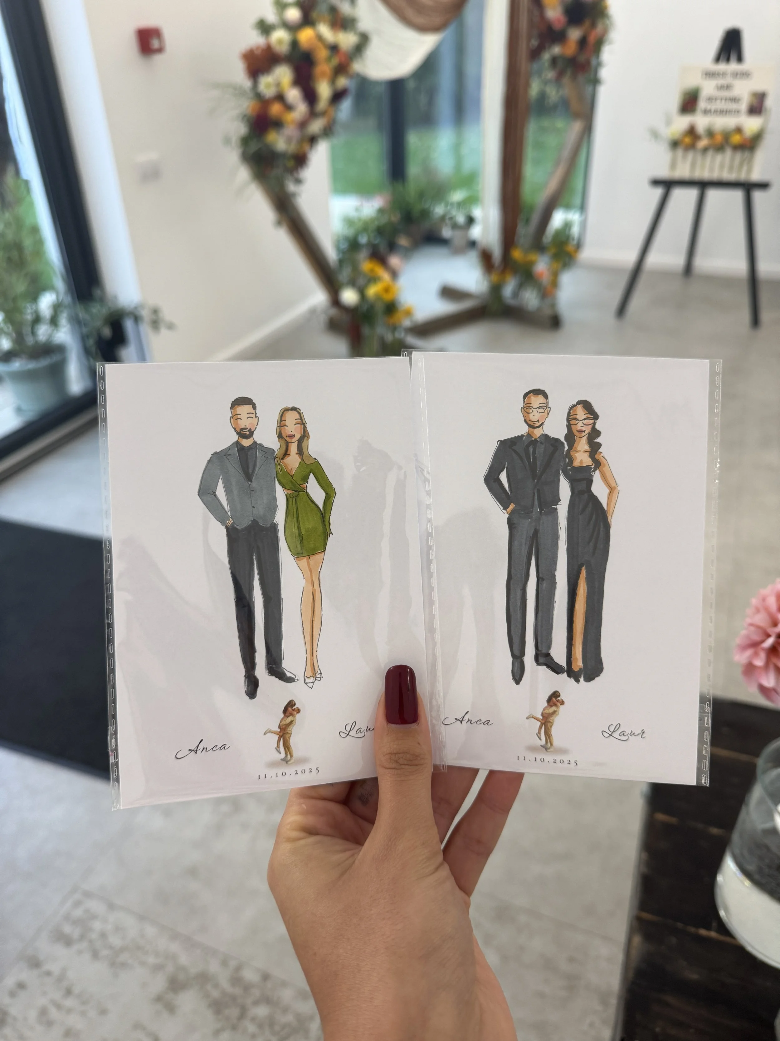 Two printed wedding invitation cards featuring illustrated couples dressed in formal attire, with the names 'Anca' and 'Laura' and the date '11.10.2025', held in a person's hand.