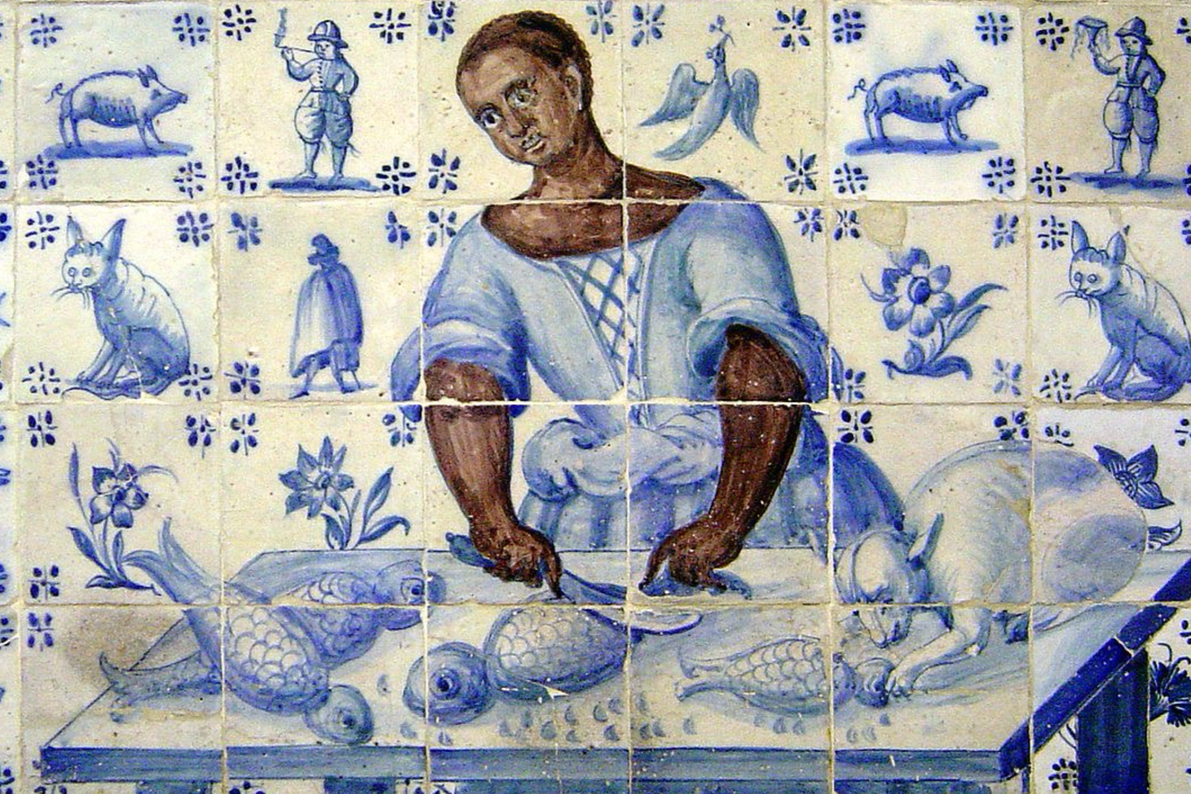 Carrelage illustrant un homme cuisinant avec des animaux et des fleurs dans un style traditionnel azulejos, principalement en bleu et blanc.