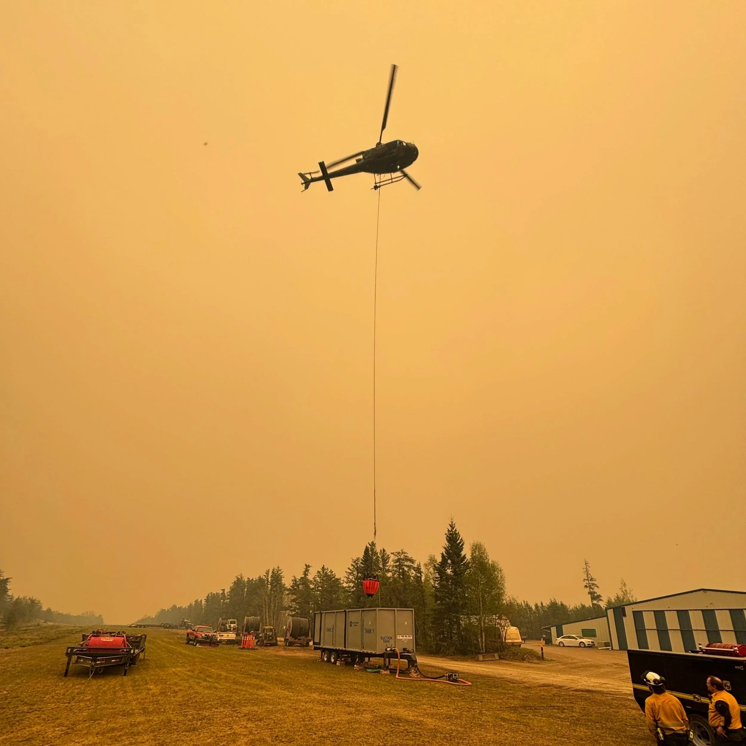 A helicopter dipping bucket into heliwell