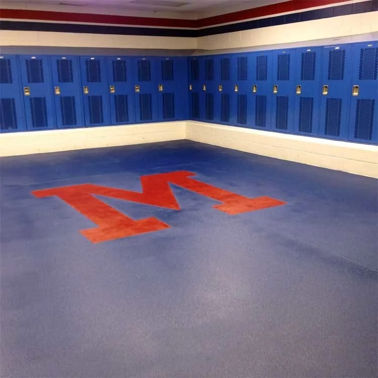 School locker room with blue lockers and a large red letter M painted on the blue epoxy-coated floor.