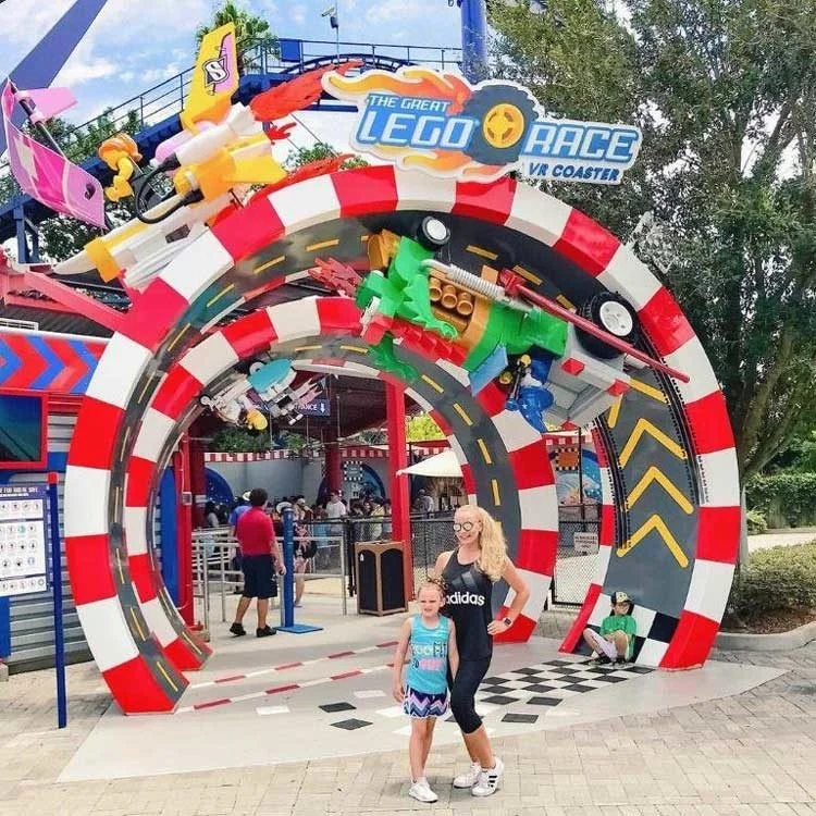 Colorful theme park ride entrance with themed figures and checkered patterns on the coated walkway.