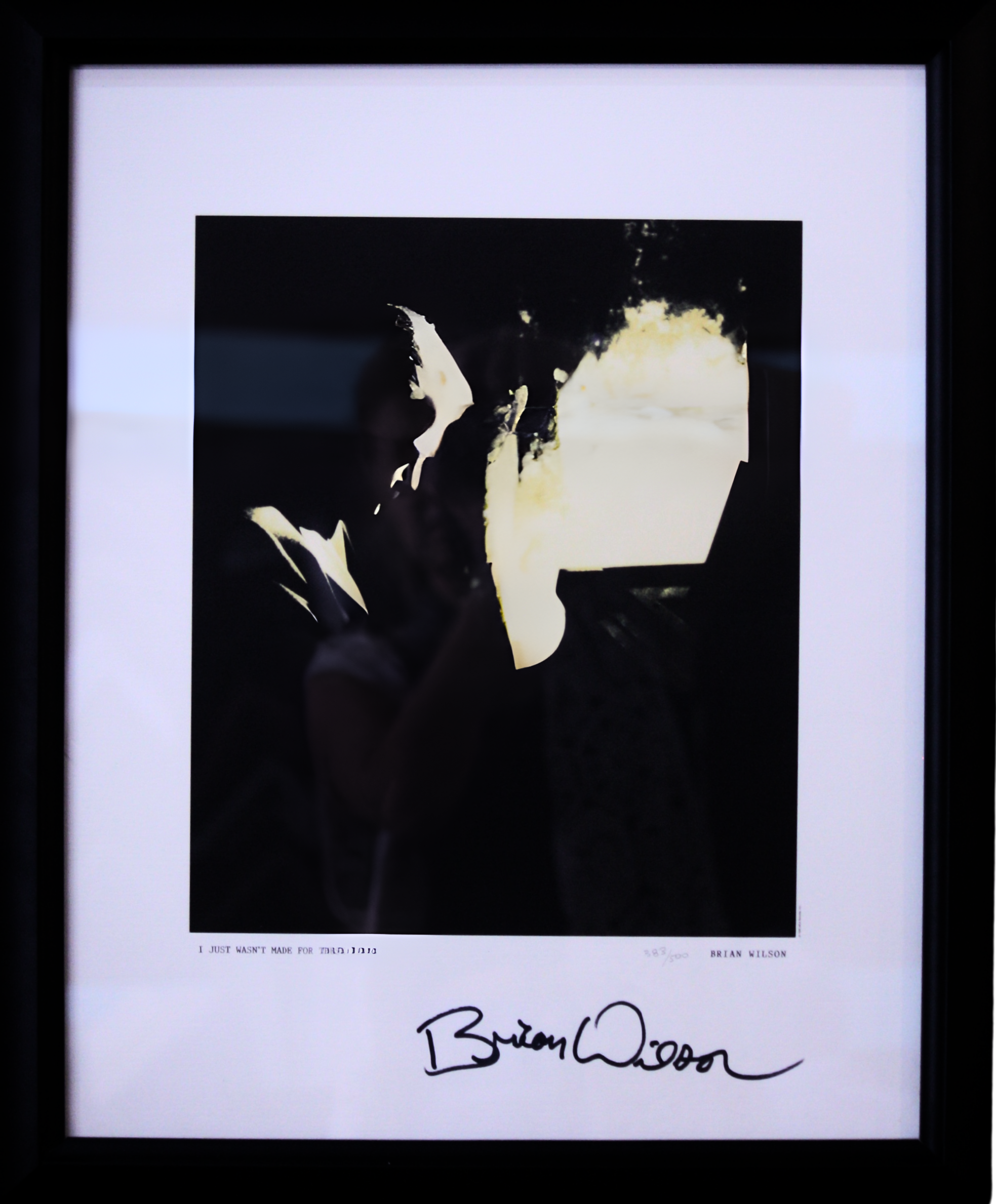 Framed art print of a dark silhouette of a man holding a phone, with a bright, abstract background, signed by Brian Wilson.