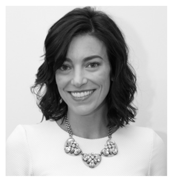 A woman with blonde hair wearing a black shirt and maroon sweater, smiling against a gray background.