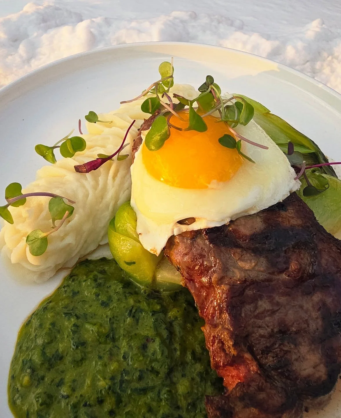 Arshla Farm Grilled Sirlion, topped by sunny side up egg, chimichurri sauce, mashed potatoes &amp; bok choy.