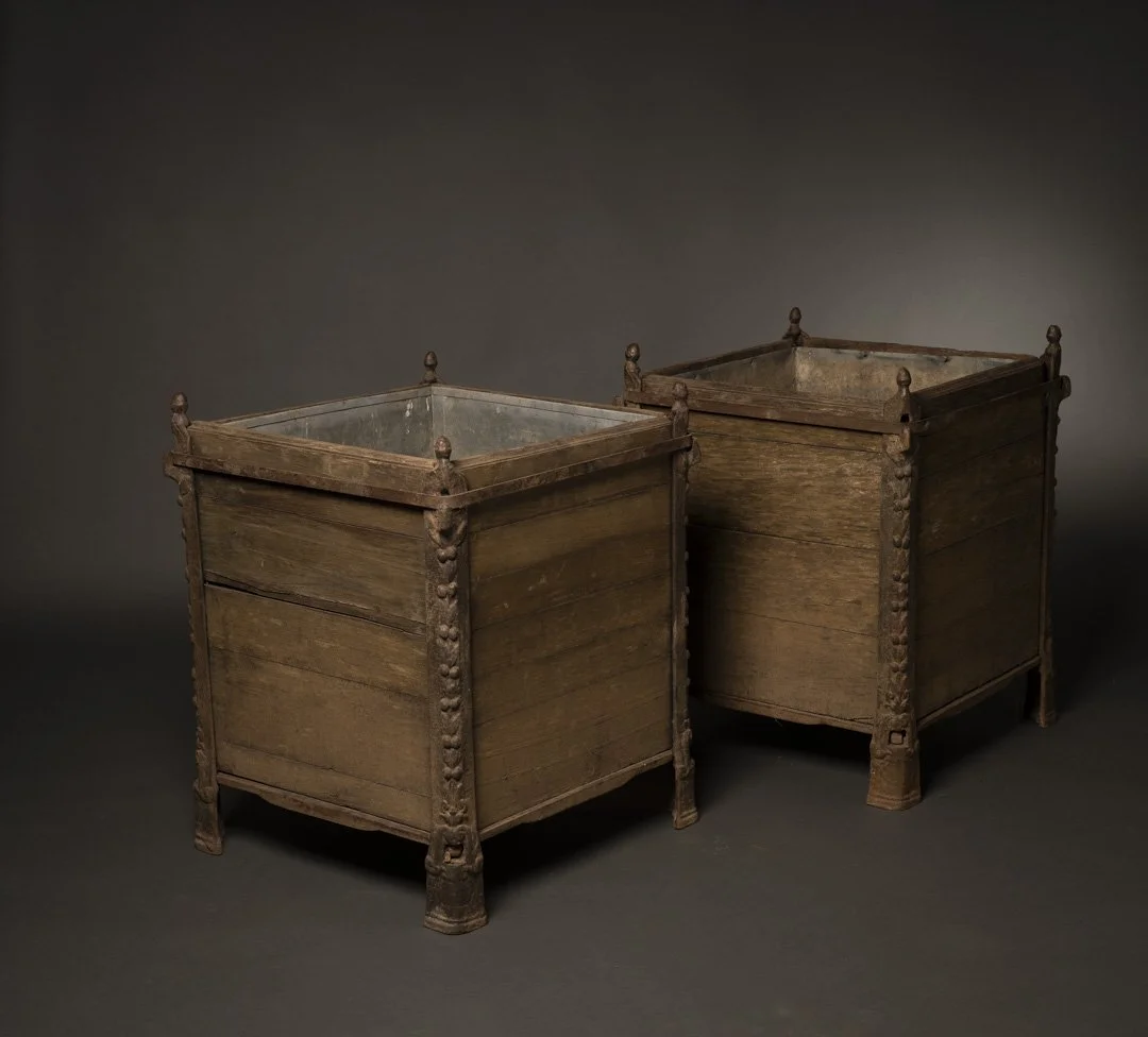Two antique wooden dresser or storage chests with decorative carved legs and platforms, placed against a dark background.