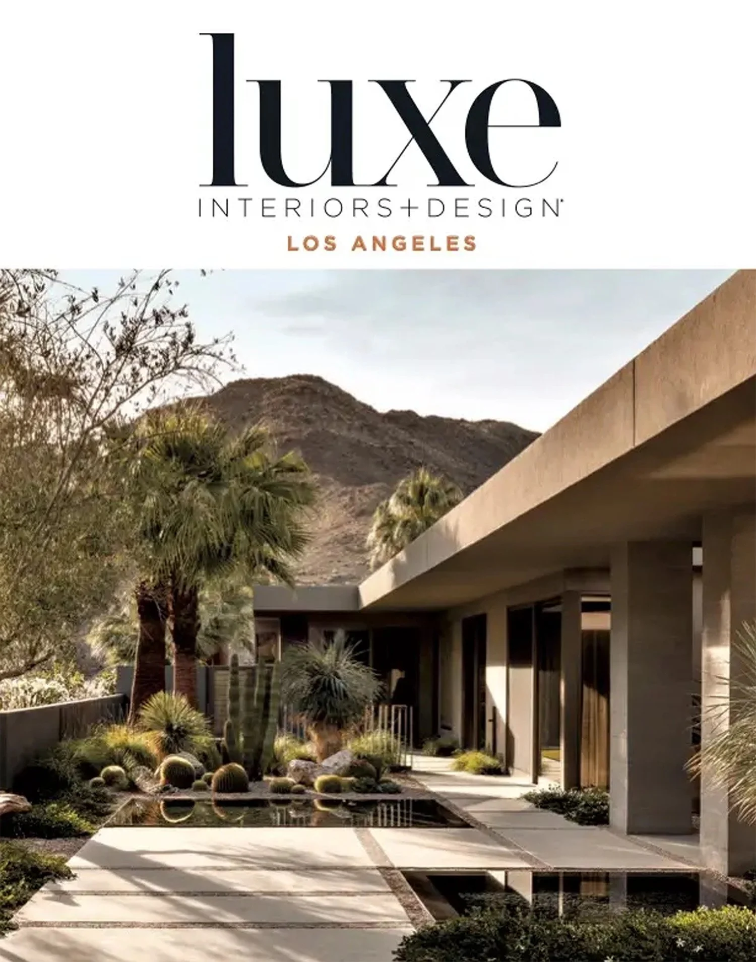 Cover of Luxe Interiors + Design magazine featuring a modern desert home with a landscaped yard including cacti and palm trees, mountain backdrop, and minimalist architecture.