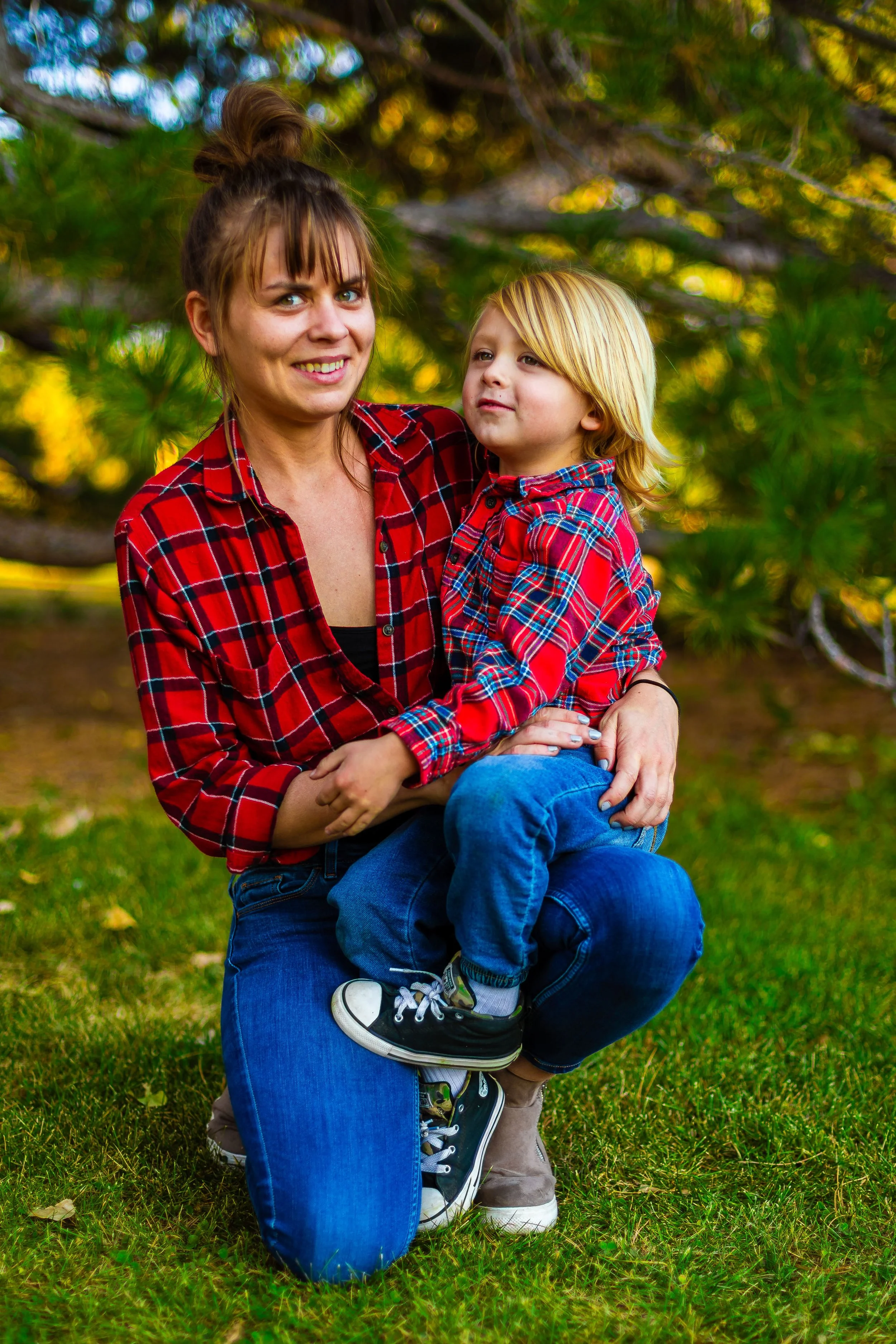 Mother and young child in red plaid shirts photographed together at a Denver park.