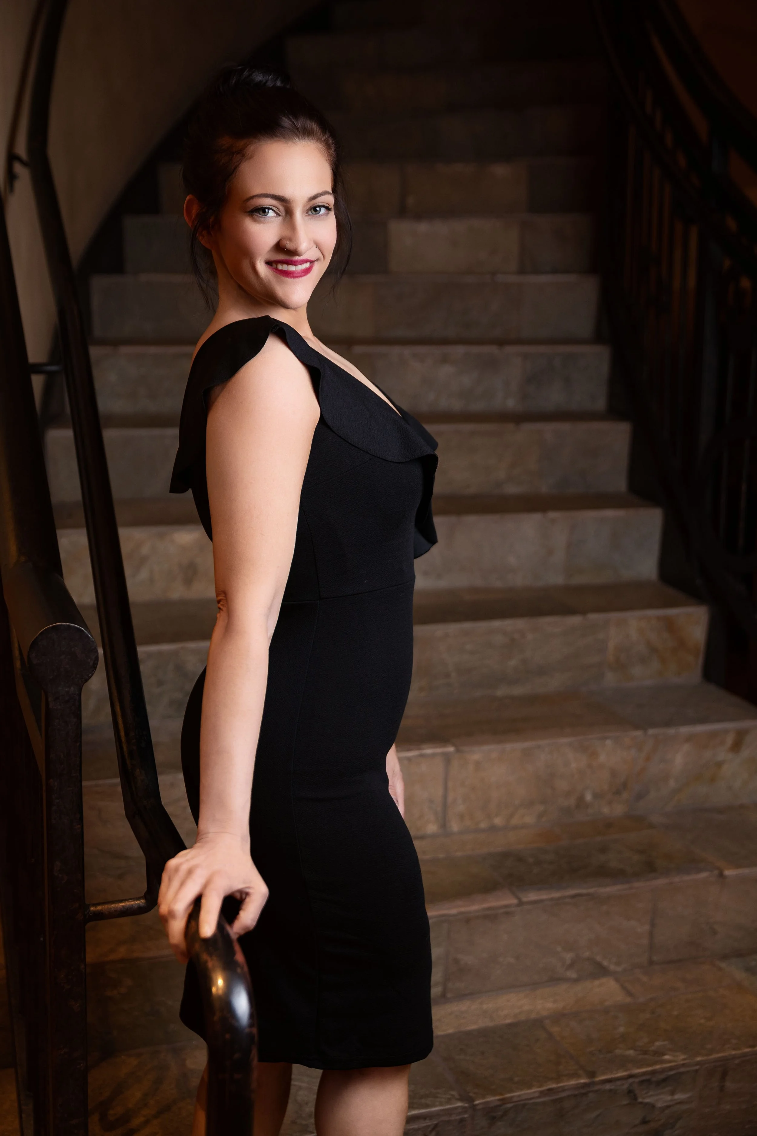 Portrait of a woman in a black dress on a stairwell in Denver, Colorado.