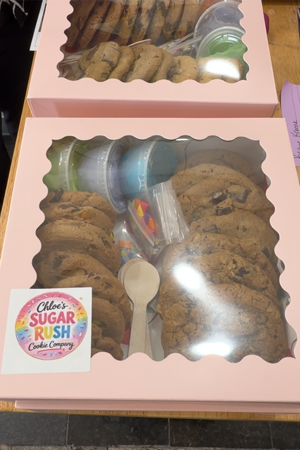 a box of cookies with icing and sprinkles