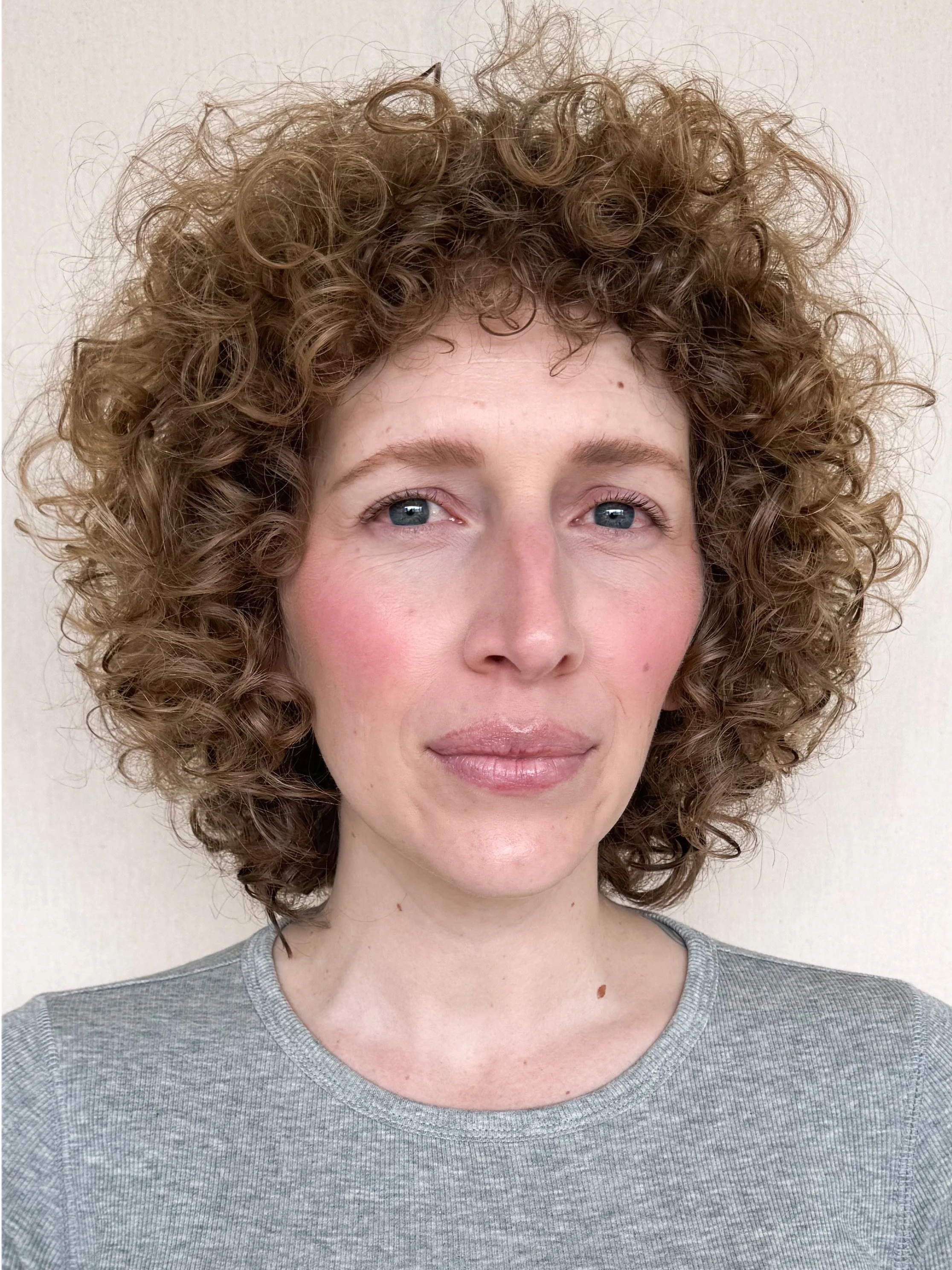 A client with beautifully defined curly hair and a custom layers haircut from a texture specialist at Little Saint Salon in NE Portland
