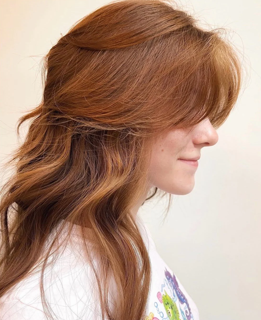 A side profile of a client with a copper 70s shag haircut and soft curtain bangs at Little Saint Salon in the Kerns neighborhood.