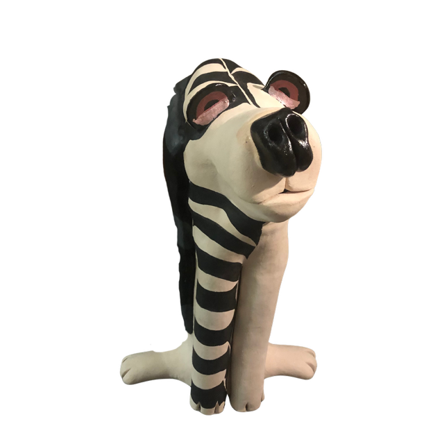 The art of Larone Hudson who is represented by Bywater Art Gallery of New Orleans Jan 2026.  A sculpture of a dog with a zebra pattern on its face and a black nose.