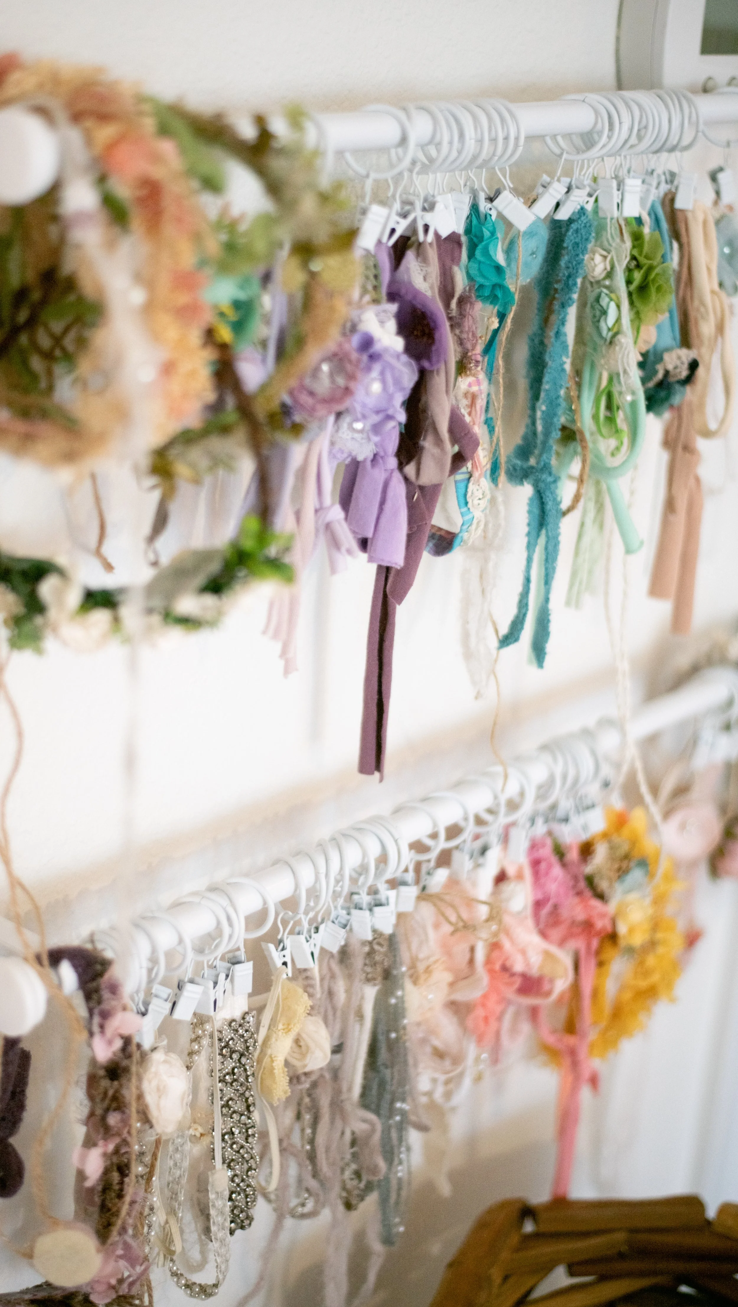 A display of various colorful hair accessories hanging on white racks.