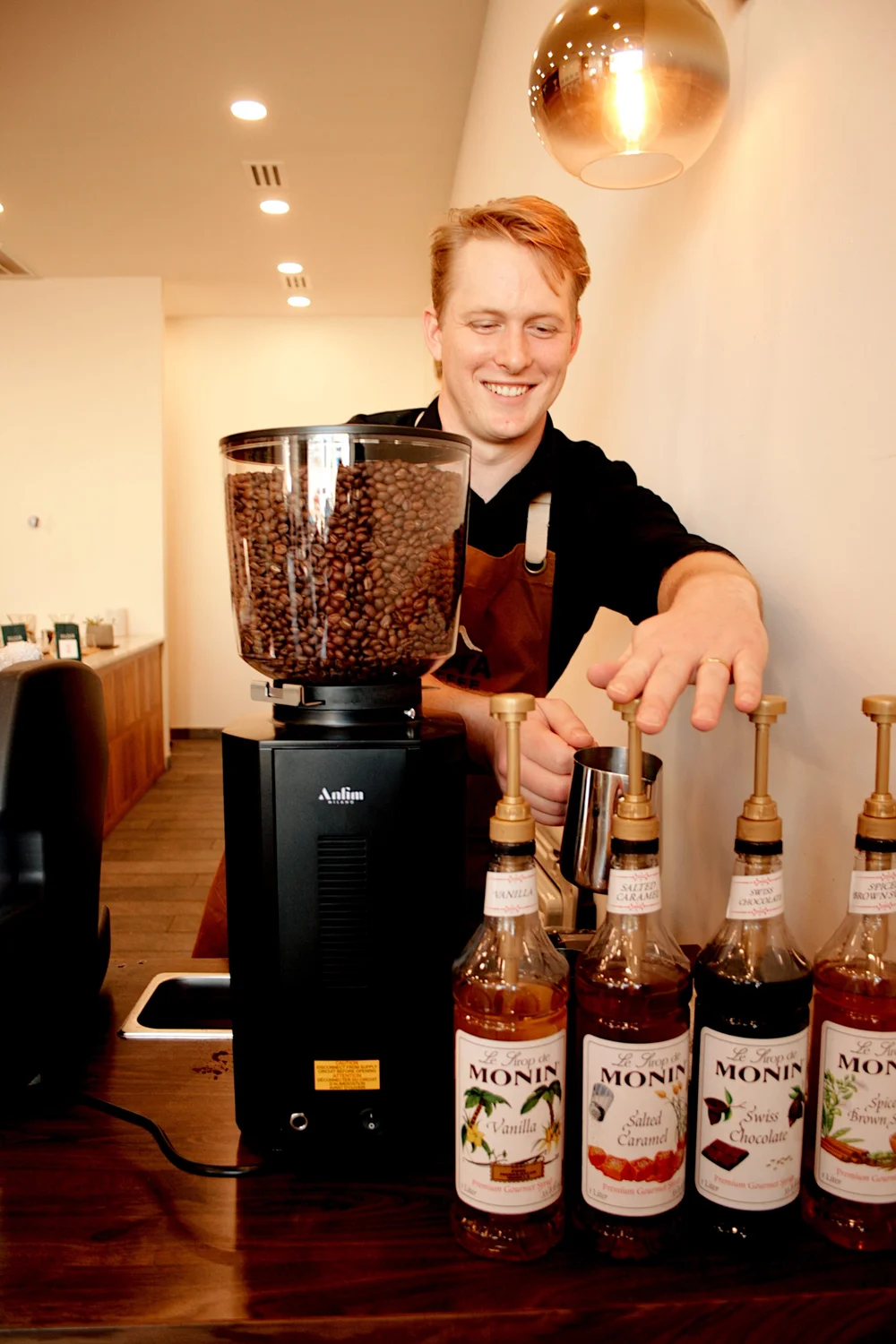 Vista Coffee Catering barista preparing drinks behind the grinder