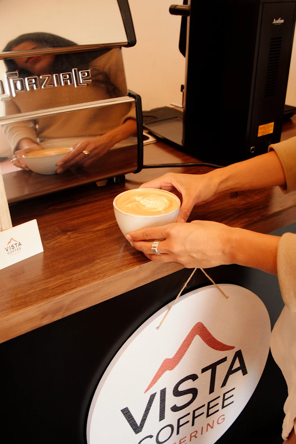 Guest picking up a handcrafted drink at the Vista Coffee espresso cart