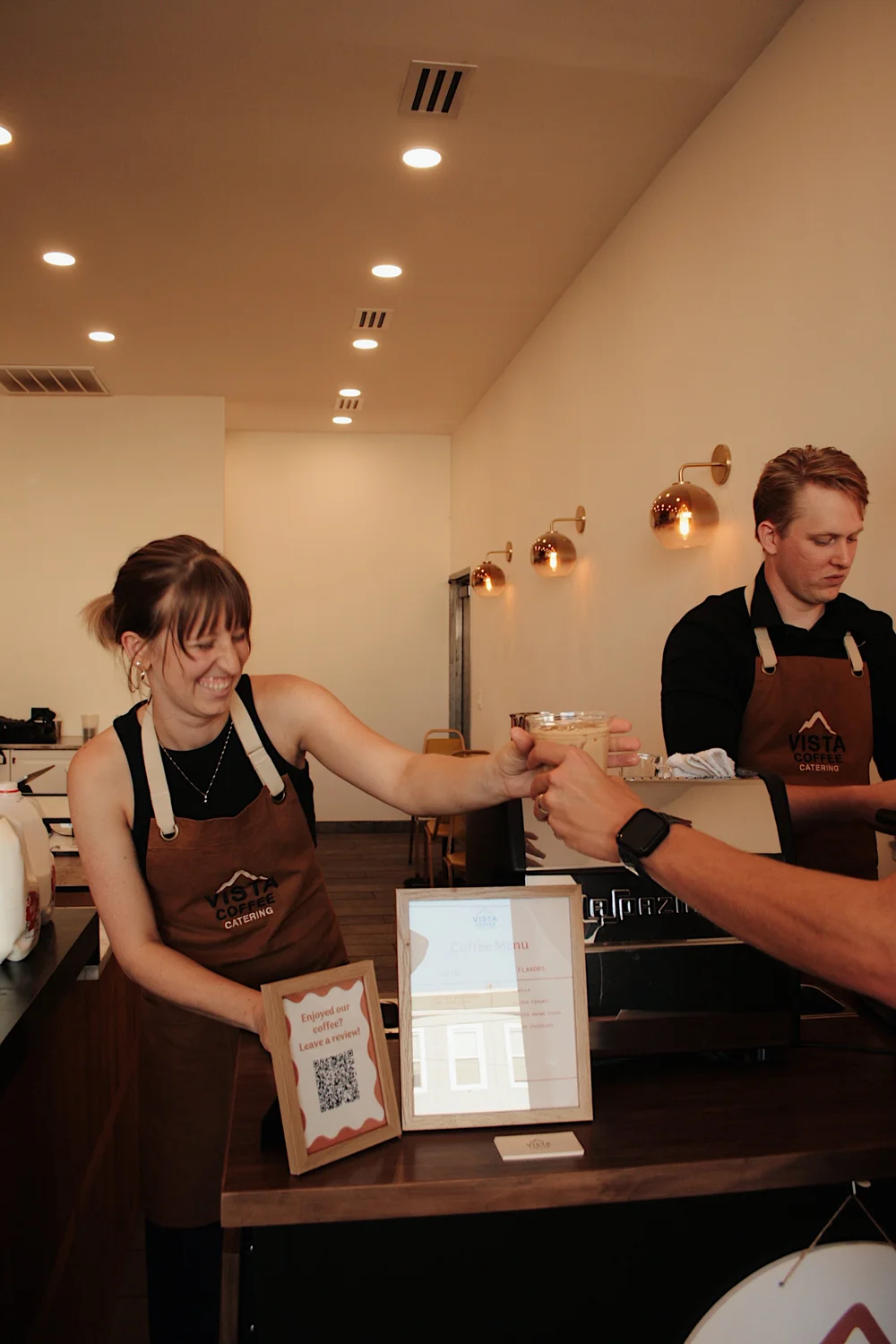 Vista Coffee Catering barista handing a finished drink to an event guest