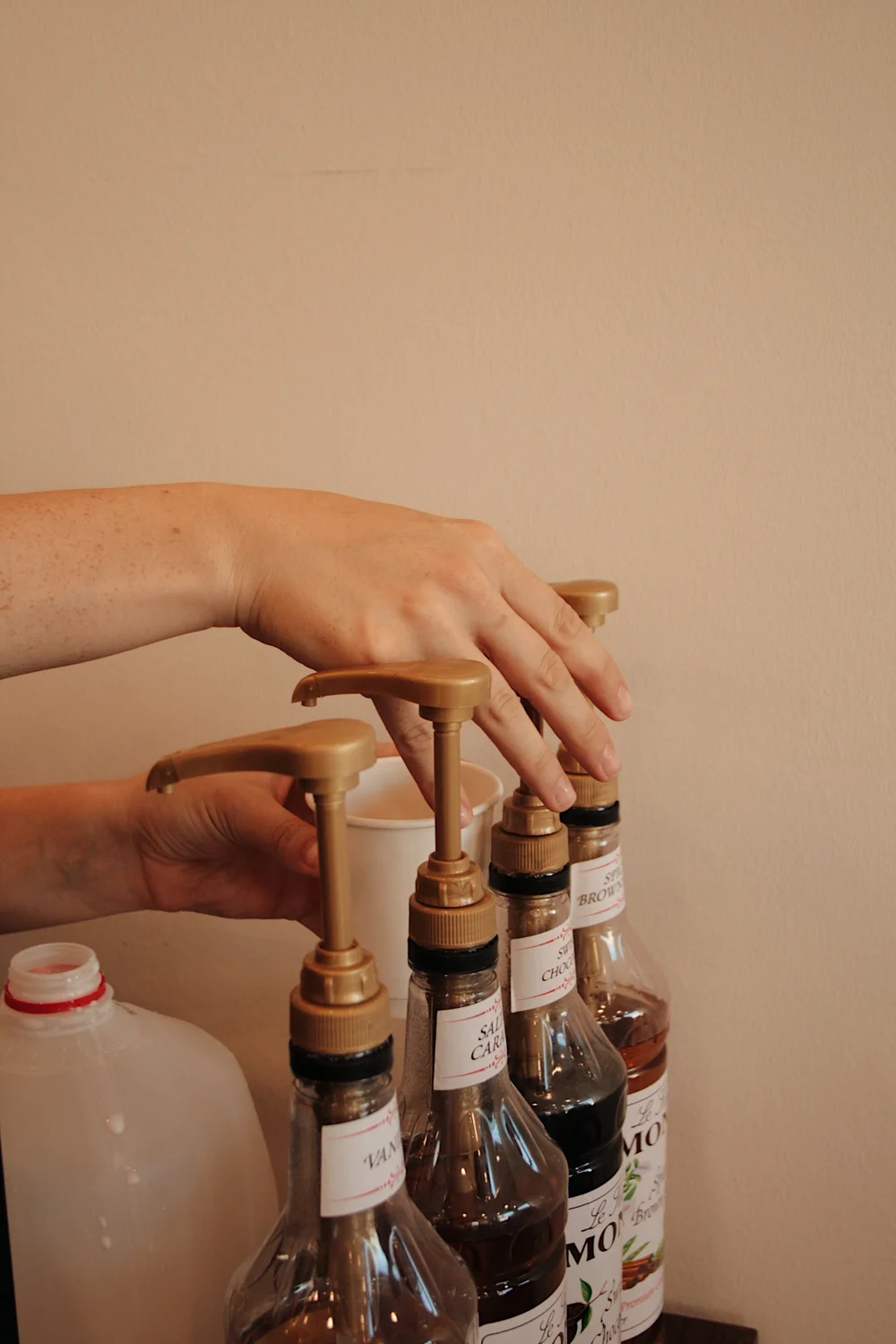 Labeled syrup pumps lined up on the Vista Coffee Catering cart