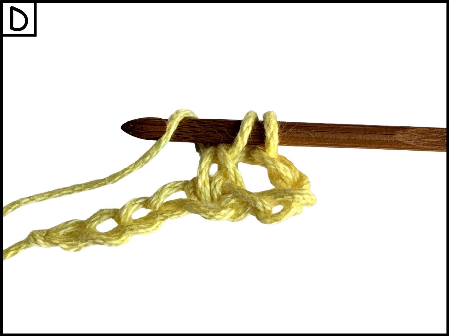 A wooden knitting needle with yellow yarn wrapped around it, forming a small knot, isolated on a white background.