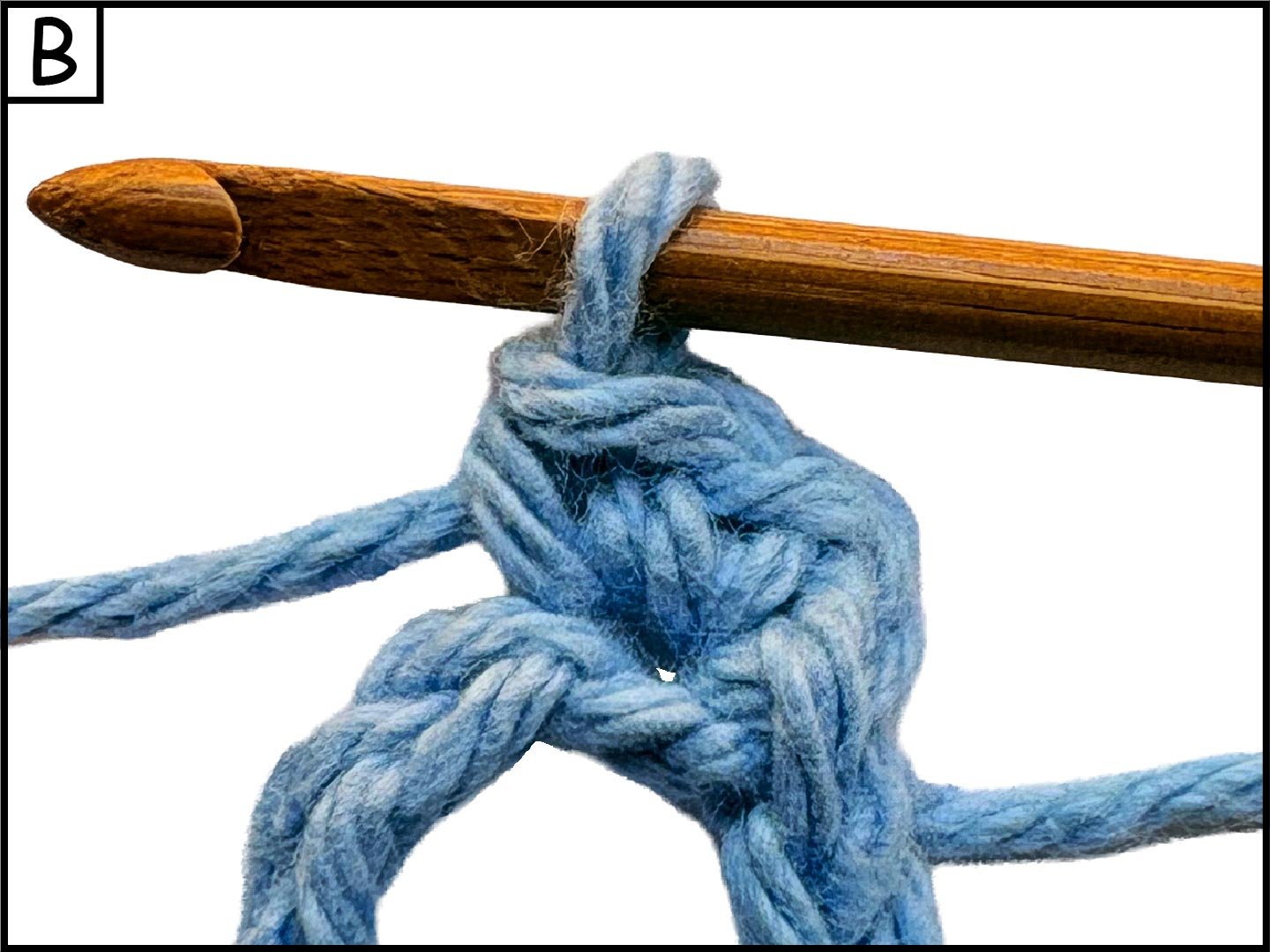 Blue yarn knotted around a wooden crochet hook, isolated on white background.