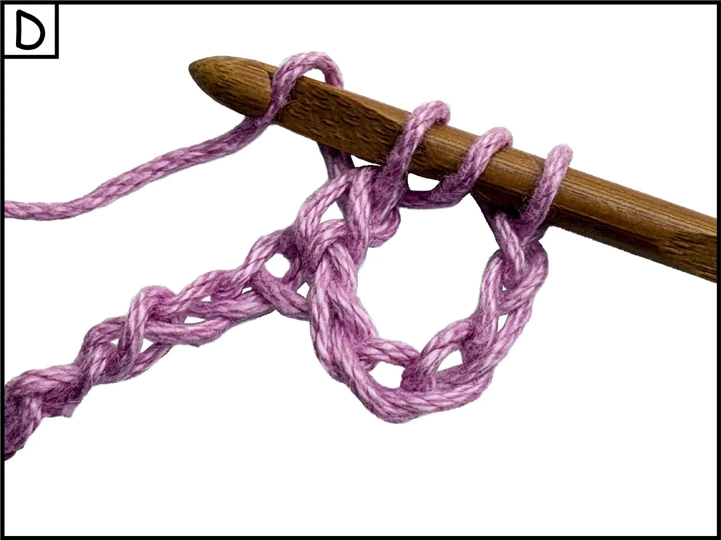 Pink yarn wrapped around a wooden knitting needle.