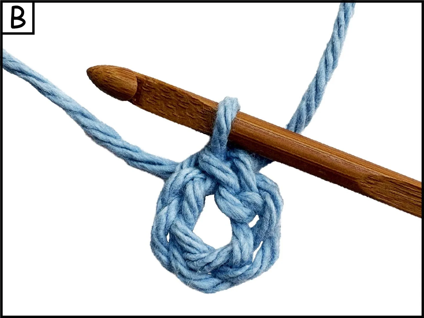 A blue yarn knot tied around a wooden crochet hook.