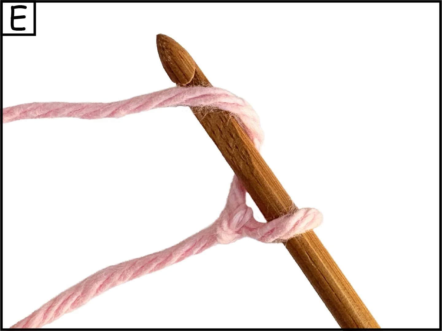 A wooden knitting needle with pink yarn looped around it, set against a white background.