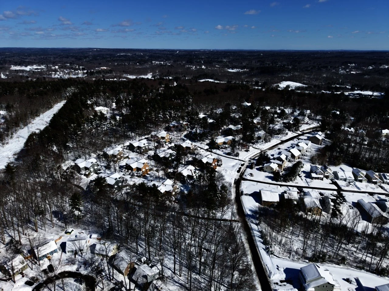 Drone, aerial photography of a recent snowfall in New England, Massachusetts, blizzard 2026, blue sky, snow