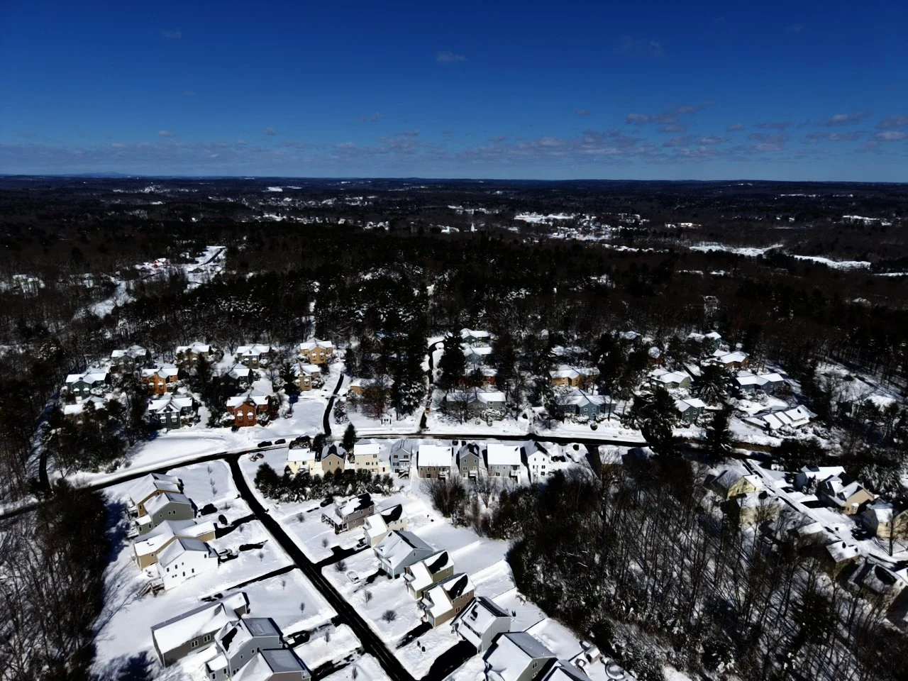 Drone, aerial photography of a recent snowfall in New England, Massachusetts, blizzard 2026, blue sky, snow