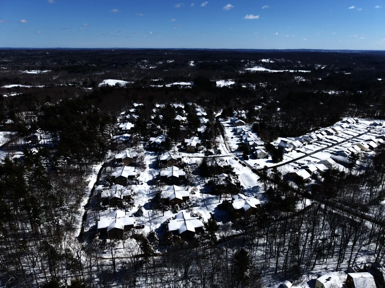 Drone, aerial photography of a recent snowfall in New England, Massachusetts, blizzard 2026, blue sky, snow