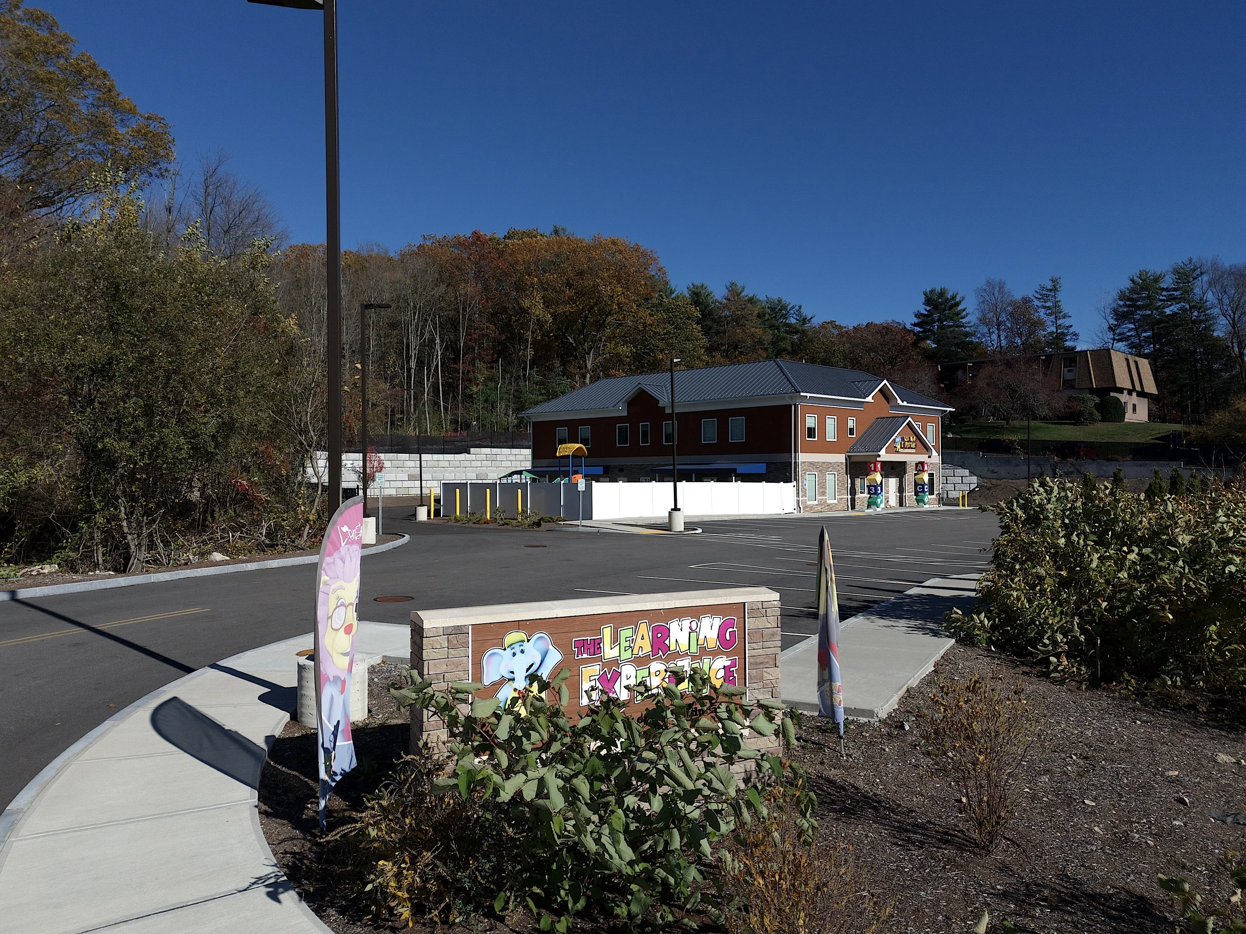 Marketing aerial, drone photo in the town of Franklin, Massachusetts of a day care center with blue skies and foliage.