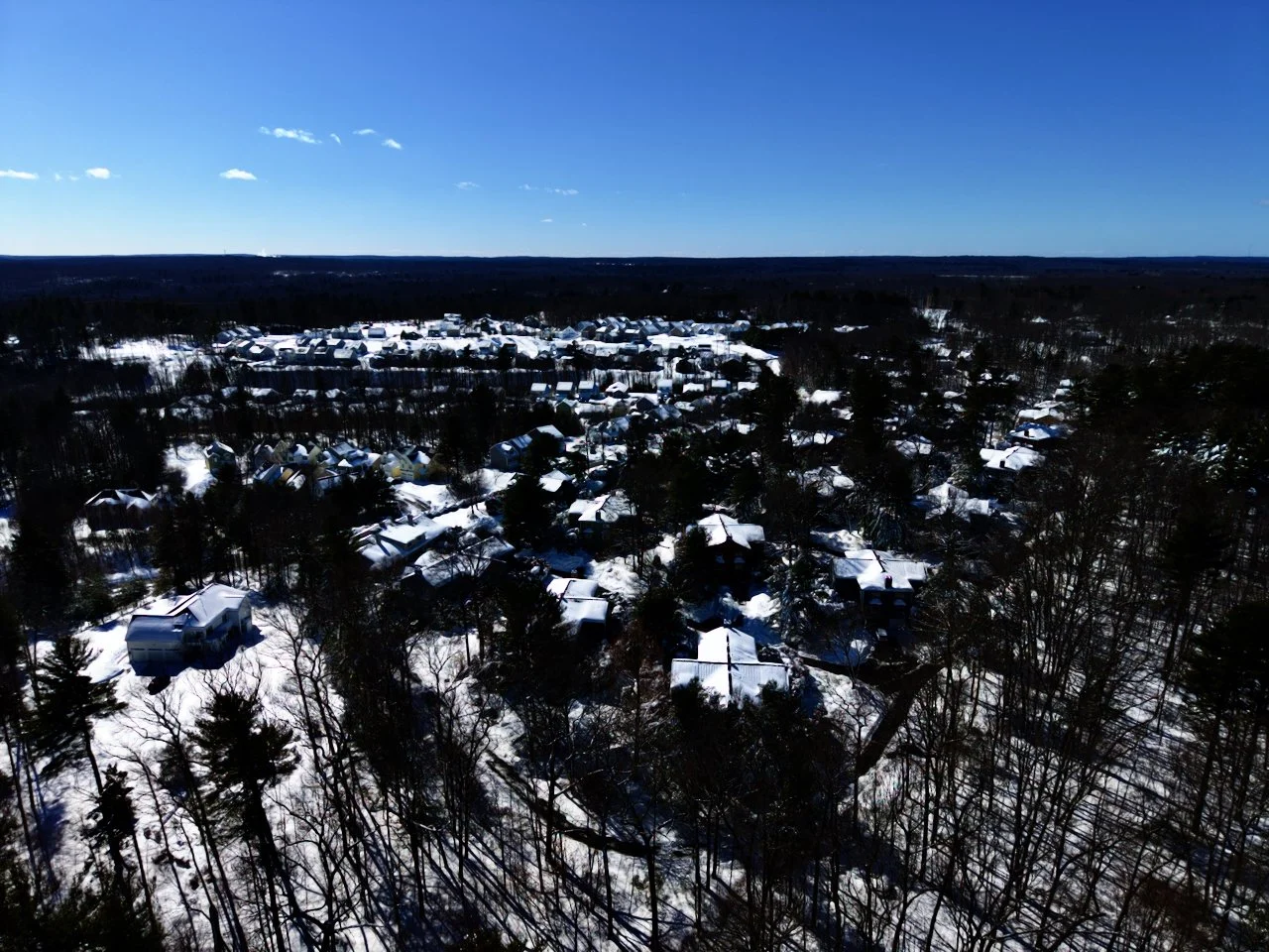 Recent drone, aerial photography snowfall in Massachusetts, New England with blue sky. Snow. Winter. Blizzard.
