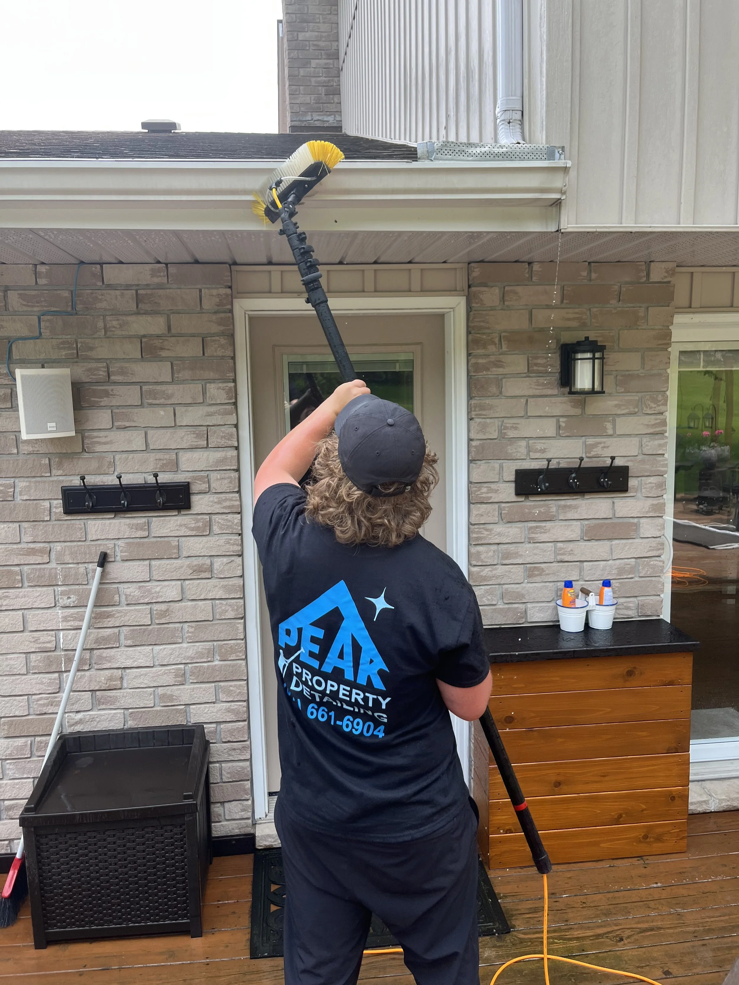 Peak Property Detailing expert cleaning eaves on a home in the Trenton, Belleville, or Frankford area—restoring proper flow and enhancing exterior appearance with professional care.