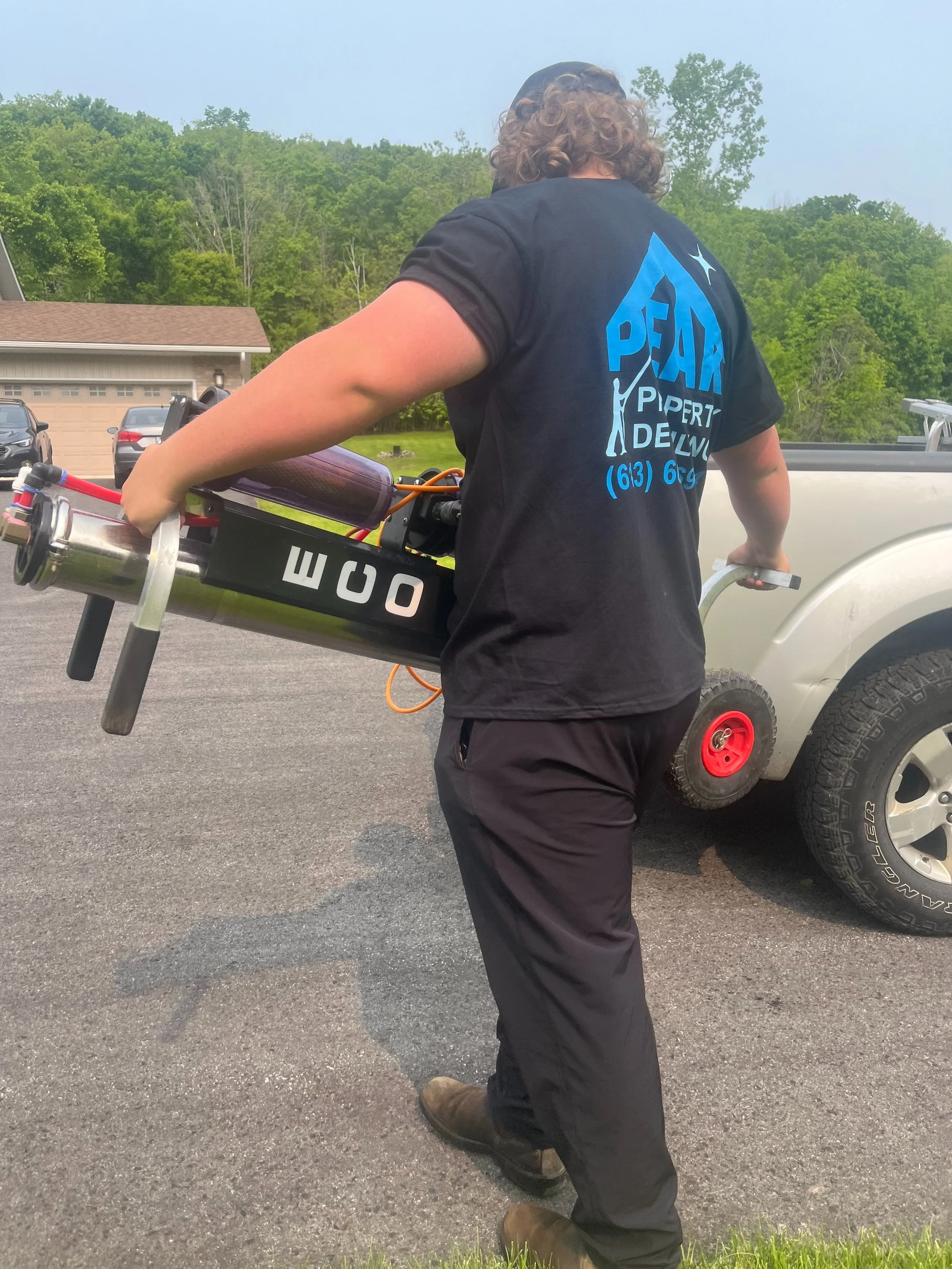 Peak Property Detailing technician packing up tools after completing an exterior cleaning service in Trenton, Belleville, or Frankford—demonstrating professionalism and attention to detail.