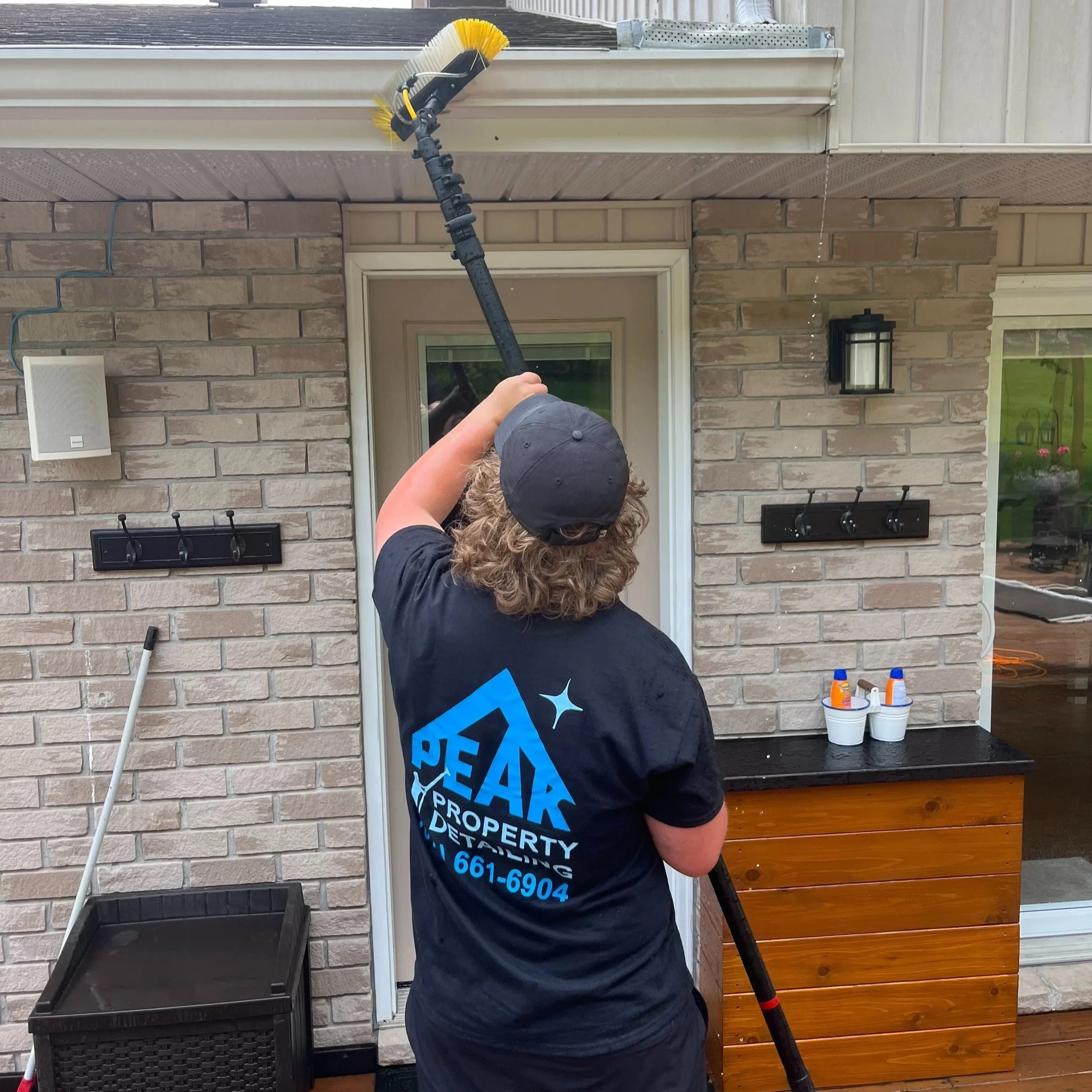 Peak Property Detailing expert cleaning eaves on a home in the Trenton, Belleville, or Frankford area—restoring proper flow and enhancing exterior appearance with professional care.