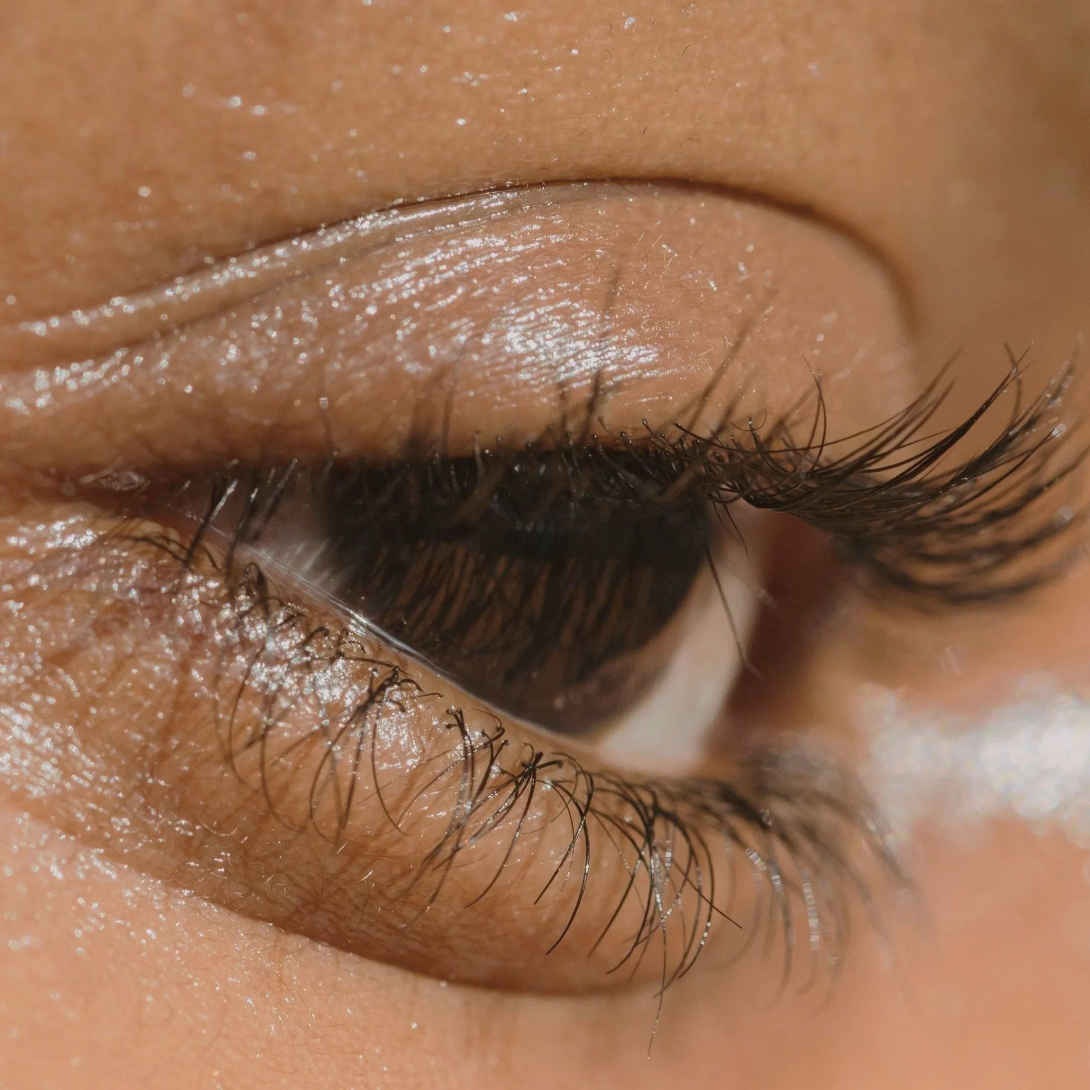 Close-up of a human eye with visible eyelashes and skin texture around it.