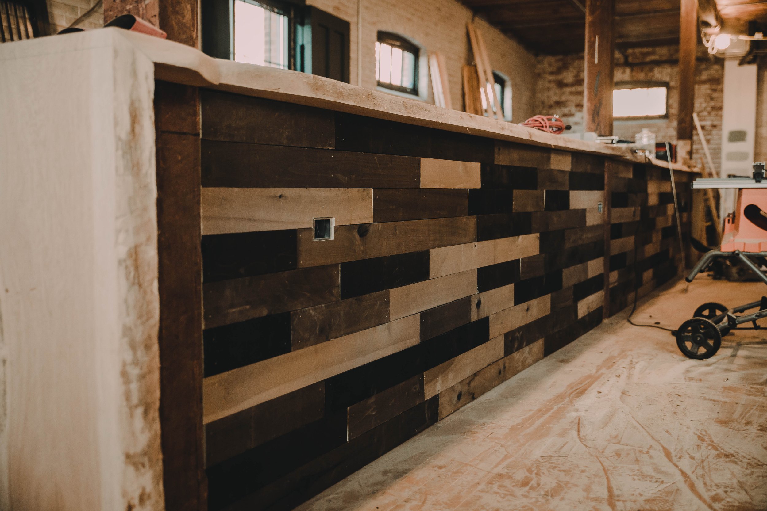 Wooden bar in a construction site with various wood pieces and construction tools around.