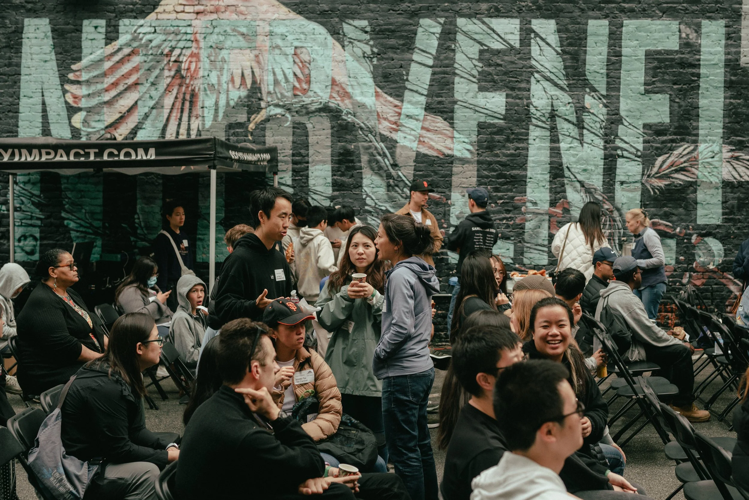 Three people in group talking during an outreach event in the Tenderloin.