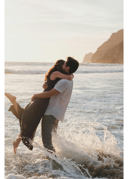 DINK couple. Couple hugging in ocean waves image.