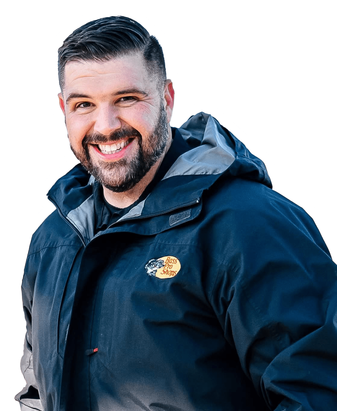 A smiling man with a beard wearing a dark blue jacket with a Bass Pro Shops logo visible.