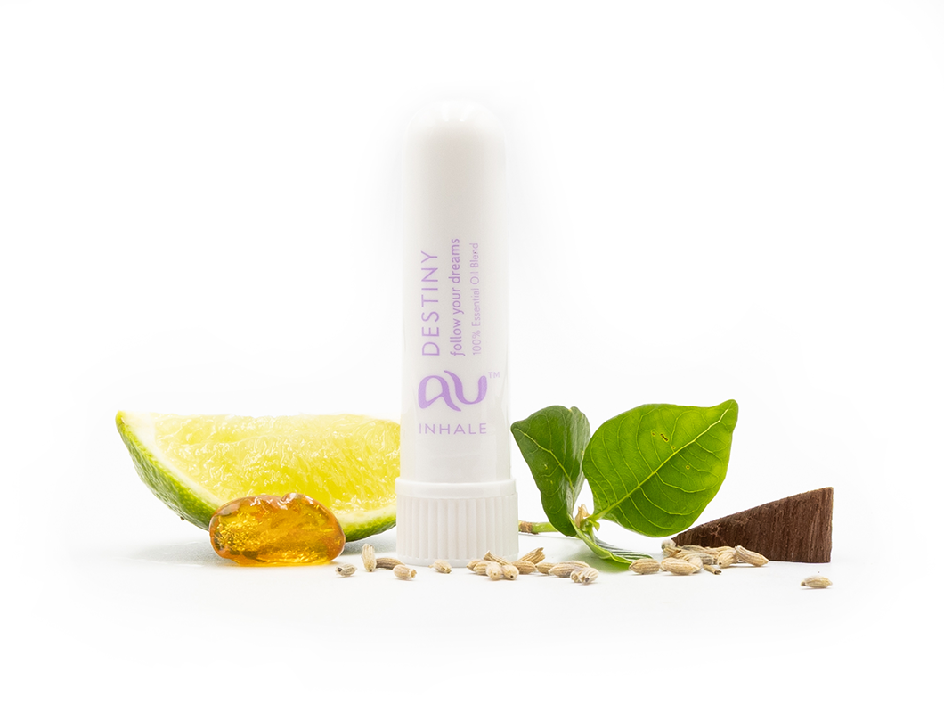 The Destiny Essential Oil inhaler is arranged on a white background surrounded by its ingredients - fruit, herbs and spices.