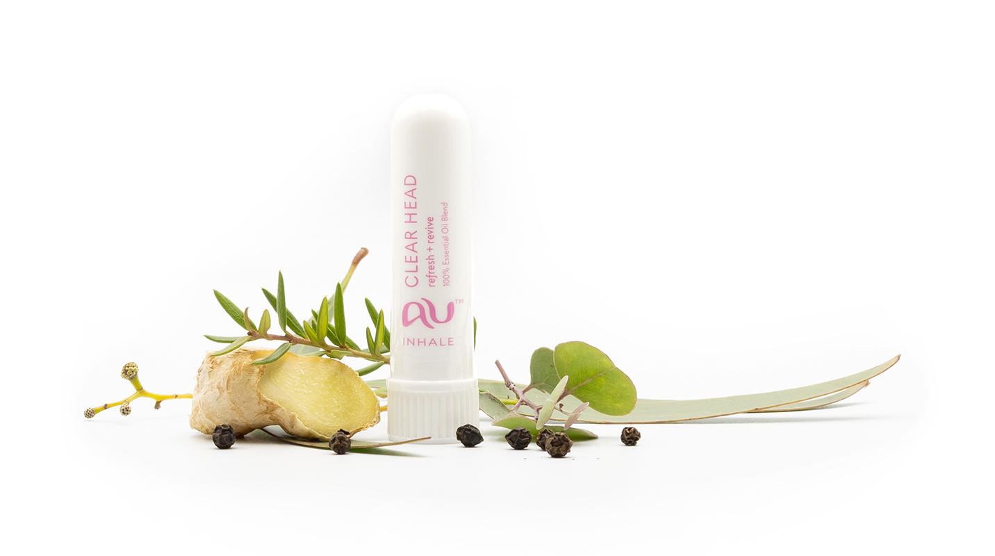 The Clear Head Essential Oil inhaler is arranged on a white background surrounded by its ingredients - fruit, herbs and spices.