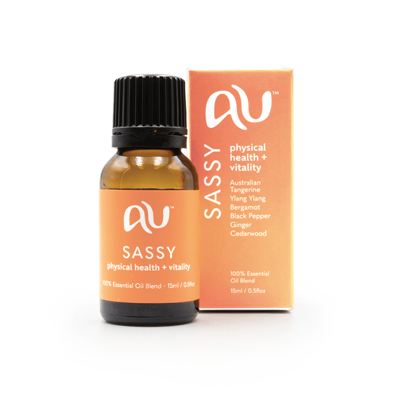The Sassy Essential Oil Blend bottle is sitting next to its box on a white background. The box and bottle are branded in a mango colour.