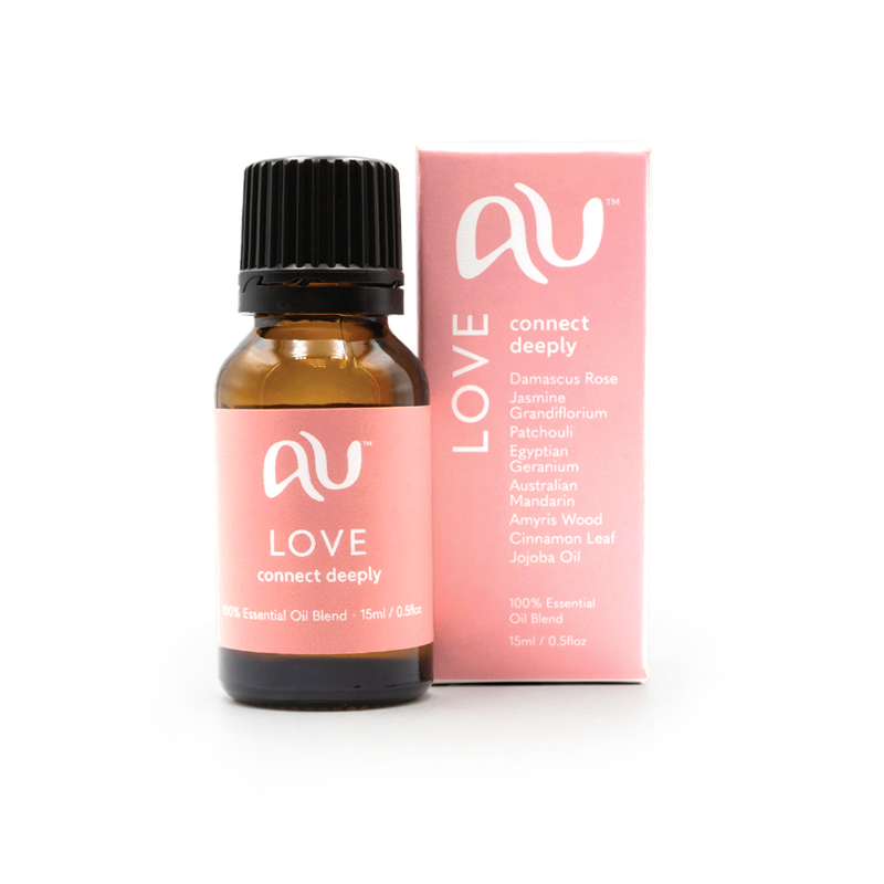 The Love Essential Oil Blend bottle is sitting next to its box on a white background. The box and bottle are branded in a soft pink colour.