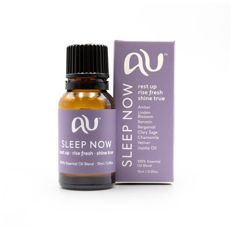 The Sleep Now Essential Oil Blend bottle is sitting next to its box on a white background. The box and bottle are branded in a soft lilac colour.