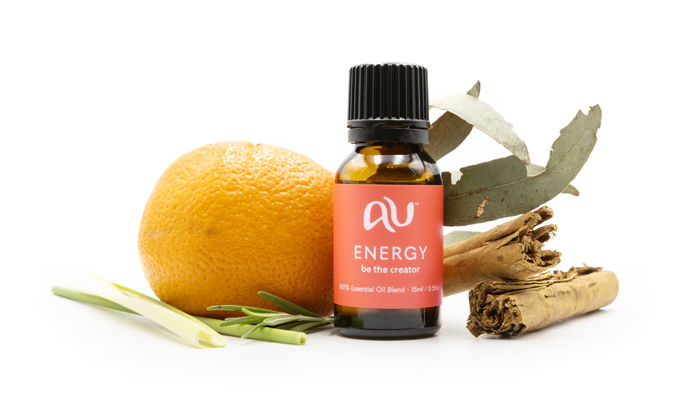 The Energy Essential Oil Blend bottle is arranged on a white background surrounded by its ingredients - fruit, herbs and spices.